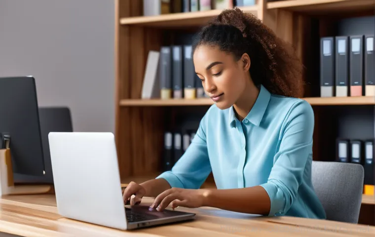 검암동 노트북 laptop 출장방문수리점 - A person in their early 30s, dressed in business casual and modest clothing, sits at a desk with a d...